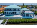 Luxury waterfront home featuring a swimming pool, a covered patio, and scenic water views for outdoor enjoyment at 935 Chipaway Dr, Apollo Beach, FL 33572