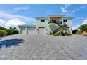 Spacious two-story home with a three-car garage and brick-paved driveway, perfect for car enthusiasts at 935 Chipaway Dr, Apollo Beach, FL 33572
