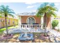 Inviting home exterior with a fountain, mature palm trees, and a charming front patio at 10918 Lake Andover Blvd, Tampa, FL 33624