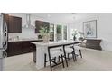 Modern kitchen featuring a large island with seating, stainless steel appliances, and stylish dark wood cabinets at 114 W Plymouth St, Tampa, FL 33603