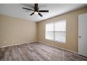 Bedroom featuring stylish ceiling fan, wood-look flooring, and a sun-filled window with white trim at 12419 Dawn Vista Dr, Riverview, FL 33578