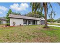 Inviting single-Gathering home featuring a well-maintained lawn and landscaping, complemented by a mature palm tree at 12601 Stone House Loop, Hudson, FL 34667