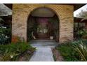Inviting brick archway, with double doors surrounded by lush landscaping, leads to the home's entrance at 17519 Drake Ct, Lutz, FL 33559