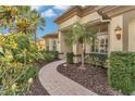 A paved walkway leads to the entrance framed by lush landscaping and mature tropical trees at 20632 Broadwater Dr, Land O Lakes, FL 34638