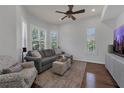 Bright living room features hardwood floors, large windows with plantation shutters, and a comfortable gray sectional at 20632 Broadwater Dr, Land O Lakes, FL 34638