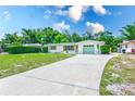 Beautiful single-story home with long driveway, a well-maintained lawn, and light-green garage and front door at 2220 Calexico S Way, St Petersburg, FL 33712
