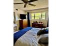 Comfortable bedroom with large window, desk, dresser, television, and neutral color palette at 2254 Norwegian Dr # 46, Clearwater, FL 33763