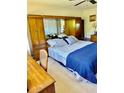 Cozy bedroom featuring a comfortable bed with a blue patterned quilt, wooden furniture, and ample closet space at 2254 Norwegian Dr # 46, Clearwater, FL 33763
