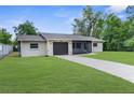 Inviting one-story home with attached garage, screened porch and lush front lawn at 2444 Magellan Ave, Spring Hill, FL 34608