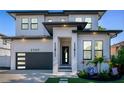 Beautiful two-story home with a modern design, black trim, and lush landscaping at 2707 W Fig St, Tampa, FL 33609