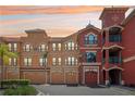 Beautiful condo exterior with private garages and colorful facade at sunset at 2757 Via Cipriani # 1121B, Clearwater, FL 33764