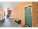 Hallway and stairs leading to a green condo entrance door at 2757 Via Cipriani # 1121B, Clearwater, FL 33764