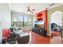Bright and airy living room featuring wood floors, ample seating, and a ceiling fan at 2757 Via Cipriani # 1121B, Clearwater, FL 33764
