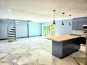 Open-concept living and kitchen area featuring marble floors, spiral stairs, and modern, stainless steel appliances at 3911 6Th W Ave, Palmetto, FL 34221