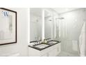 Contemporary bathroom with double vanity, marble countertop, framed mirrors and sleek glass-enclosed shower at 411 E Shore Drive # 214, Clearwater Beach, FL 33767
