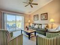 Comfortable living room with large sliding glass doors opening to an outdoor patio overlooking the golf course at 6059 Bahia Del Mar Blvd # 235, St Petersburg, FL 33715