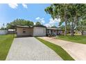 Charming single-story home with fresh landscaping, cozy front porch with chairs, and gravel driveway to the garage at 7494 7Th N St, St Petersburg, FL 33702