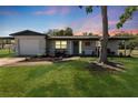 Charming single-story home featuring a well-manicured lawn, fresh landscaping, and inviting front porch at 7494 7Th N St, St Petersburg, FL 33702