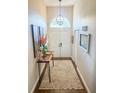 Inviting foyer featuring a high ceiling, chandelier, decorative table, and double doors at 923 Tuscanny St, Brandon, FL 33511