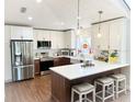 Bright kitchen featuring white cabinets, stainless steel appliances, a breakfast bar, and pendant lighting at 923 Tuscanny St, Brandon, FL 33511