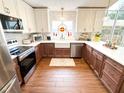 Well-lit kitchen with stainless steel appliances, a farmhouse sink, and custom two-tone cabinetry at 923 Tuscanny St, Brandon, FL 33511
