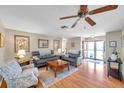 Spacious living room with wood flooring, neutral walls, modern furnishings, and a ceiling fan, creating an inviting atmosphere at 9335 Stonewall, New Port Richey, FL 34655