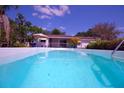 Inviting pool with clear blue water, surrounded by lush landscaping and a covered patio area at 934 Jerry Smith Rd, Dover, FL 33527
