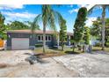 Quaint single-story home with a garage, well-maintained front yard, unique landscaping, and mature trees at 936 Alcazar Way S, St Petersburg, FL 33705