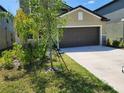 Exterior view of the house, showing the garage, lawn, and landscaped foliage at 12537 Timber Moss Ln, Riverview, FL 33579