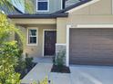 View of the home's exterior with front door, garage, landscaped foliage and stone details at 12537 Timber Moss Ln, Riverview, FL 33579
