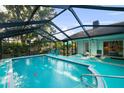 Beautiful screened pool area with ample seating and a tranquil backyard view at 14702 Dartmoor Ln, Tampa, FL 33624