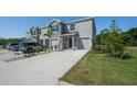 Two-story townhome with light gray exterior, garage, and manicured lawn at 1926 Pleasant Maple Ct, Bradenton, FL 34211