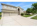 Beautifully landscaped two-story home with a three-car garage, lush green lawn, and freshly painted exterior at 20251 Ravens End Dr, Tampa, FL 33647