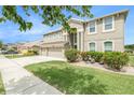 Landscaped two-story home boasts a three-car garage, lush green lawn, and fresh exterior paint at 20251 Ravens End Dr, Tampa, FL 33647