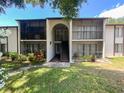 Charming condo building featuring a screened-in balcony, inviting entryway, and well-maintained landscaping at 2643 Pine Ridge S Way # A1, Palm Harbor, FL 34684