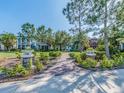 Picturesque community entrance with lush landscaping, brick pathways, and views of colorful residential homes at 311 Vista Cruiser Ln, Oldsmar, FL 34677