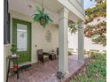 Cozy front porch with brick flooring, potted plants, and comfortable seating for relaxing outdoors at 311 Vista Cruiser Ln, Oldsmar, FL 34677