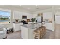 Bright kitchen with white cabinets, stainless steel appliances, and a granite island at 33030 Major Oak Dr, Wesley Chapel, FL 33545