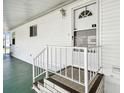 Inviting front entrance with white door and modern railing on a covered porch at 34506 Rose N Dr, Pinellas Park, FL 33781