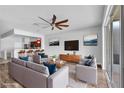 Open-concept living room with a modern ceiling fan, stylish furniture, and a view of the adjacent kitchen at 4862 Pond Ridge Dr, Riverview, FL 33578