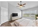 Serene main bedroom with a ceiling fan, large window with a water view, and a spacious layout at 4862 Pond Ridge Dr, Riverview, FL 33578