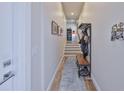 Inviting hallway with wooden floors, storage rack, leading to staircase and other living spaces at 4910 W Mcelroy Ave # 6, Tampa, FL 33611