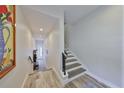 Bright hallway showcasing staircase with open floor plan leading to a welcoming white door at 4910 W Mcelroy Ave # 6, Tampa, FL 33611