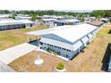 An aerial view of the property showing its white roof, carport, landscaping, and neighborhood at 5646 Cheyenne St, Zephyrhills, FL 33542