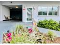 Inviting condo entrance with lovely landscaping, bench, lighting, and a peek at the inside seating area at 5660 80Th N St # C101, St Petersburg, FL 33709