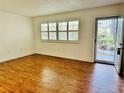 Bright living room with shuttered window, wood-look flooring, and a front door view at 5660 80Th N St # C101, St Petersburg, FL 33709