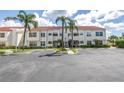Exterior view of a condominium building with tropical landscaping, parking, and tile roofing at 6011 Bahia Del Mar Blvd # 158, St Petersburg, FL 33715
