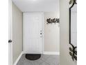 Condo front door, light gray tile, coat hooks, and a decorative mirror at 6011 Bahia Del Mar Blvd # 158, St Petersburg, FL 33715