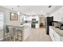 Bright kitchen with stainless steel appliances, light wood floors, and granite countertops at 701 Millifold Pl, Brandon, FL 33510