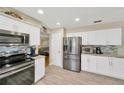 Bright and modern kitchen with stainless steel appliances, white cabinets, and bar seating at 701 Millifold Pl, Brandon, FL 33510